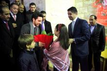 H.R.H. Crown Prince Al Hussein bin Abdullah II with H.R.H. Prince Hashim bin Abdullah II receives flowers from local children during the Christmas tree lighting ceremony  in the city of Al Fuheis, 2013